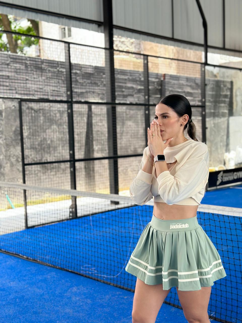 Mujer con conjunto deportivo falda, top y manguito de Fit Zone, vista frontal