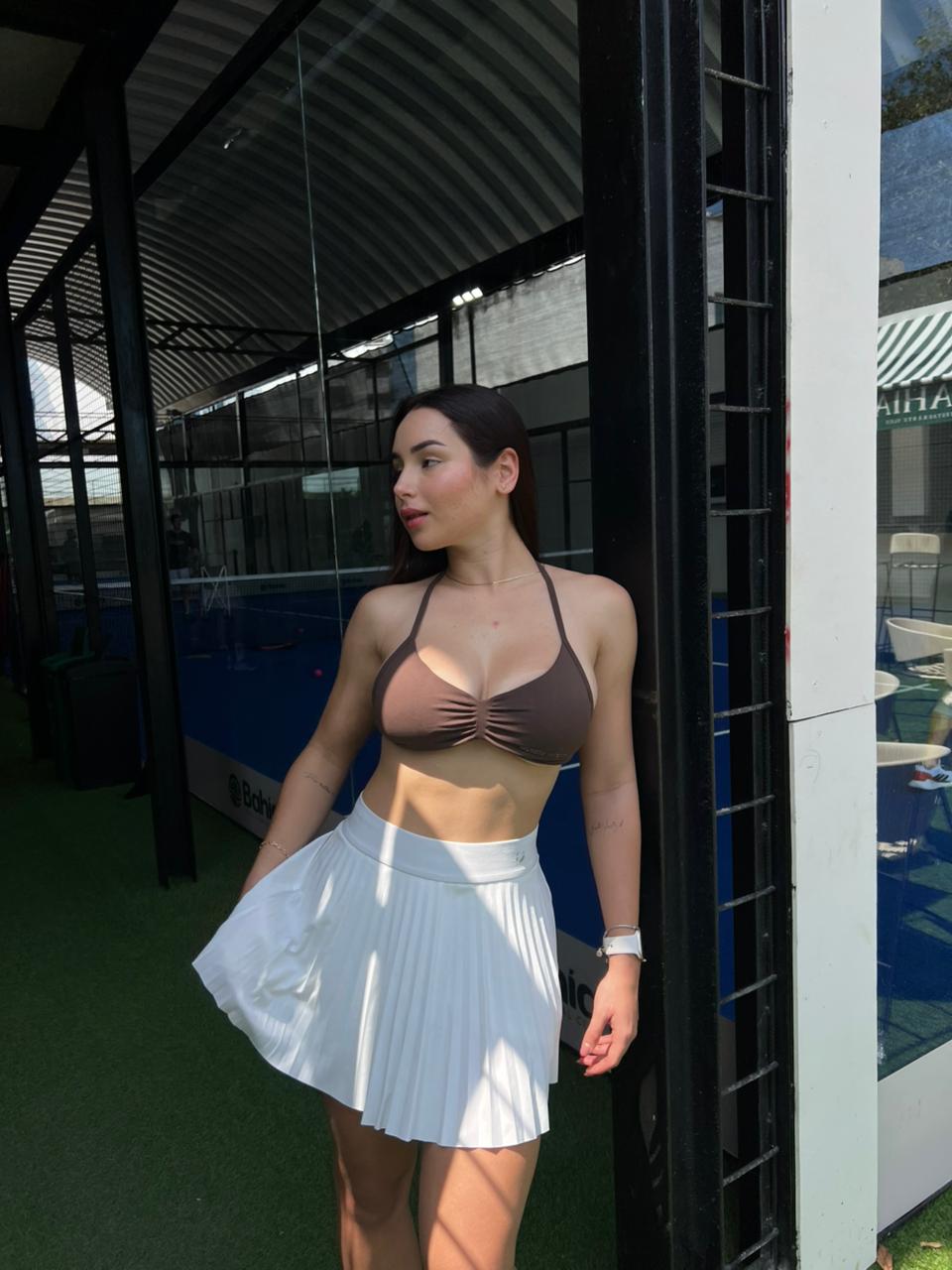 Mujer con top deportivo Aura de Fit Zone, vista frontal en estudio