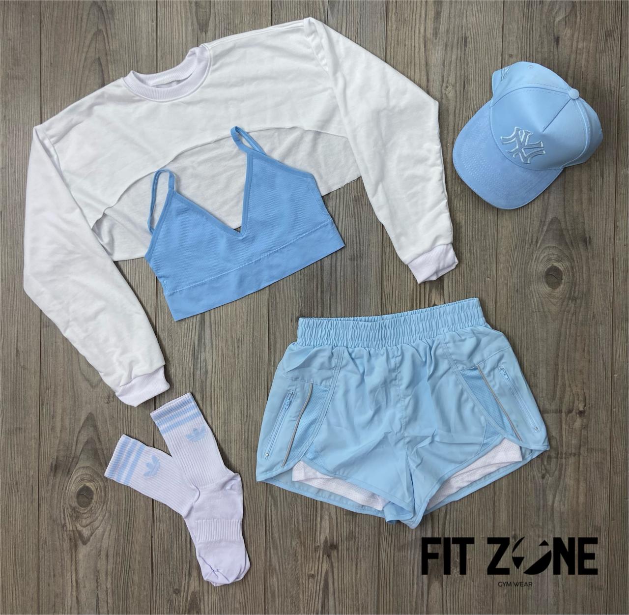 Mujer con conjunto deportivo short running, top y manguito de Fit Zone, vista frontal